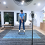 Person practicing golf swings in a living room with a golf simulator setup